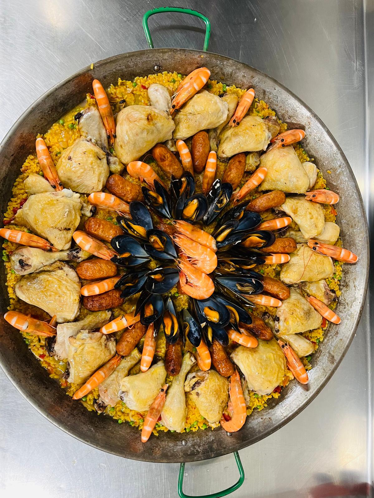 Paella aux fruits de mer avec moules, crevettes et riz jaune dans un plat traditionnel